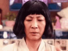 scene from everything everywhere all at once. An Asian lady lifts up her hands. All her fingers are like limp sausages