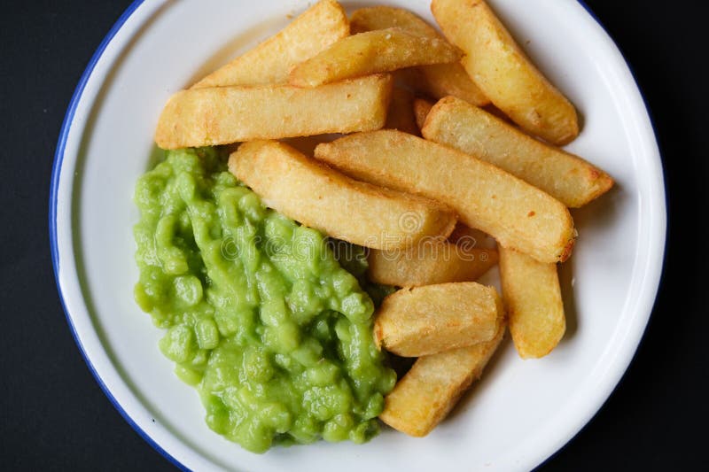 A plate with mashed peas next to some french fries.